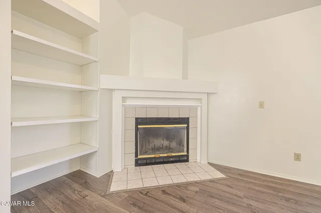 a living room with a fireplace and a wooden floor