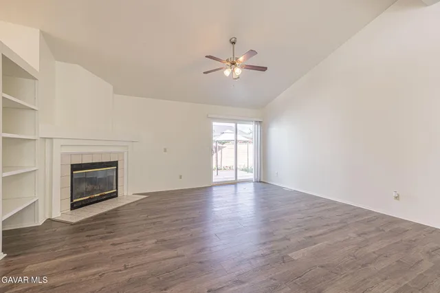 a view of an empty room with a fireplace and a window