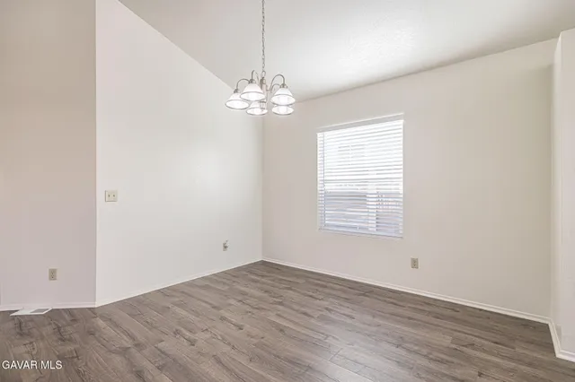an empty room with wooden floor and window