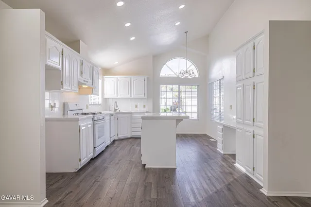 a view of a kitchen with wooden floor and electronic appliances