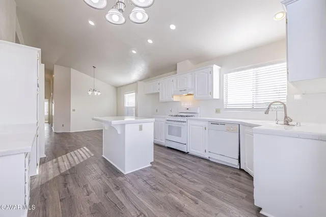 a kitchen with a white wooden cabinets and white appliances