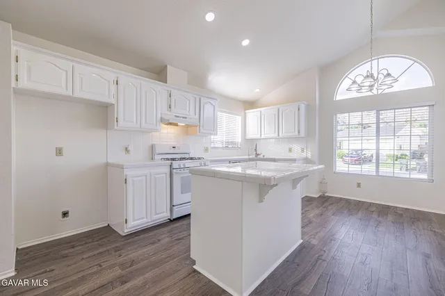 a kitchen with a white cabinets stove and sink