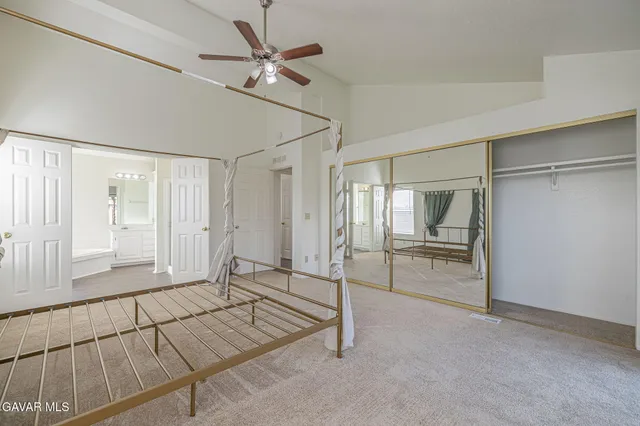 a spacious bedroom with a bed and a chandelier