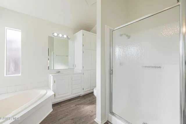 a bathroom with a tub shower and sink