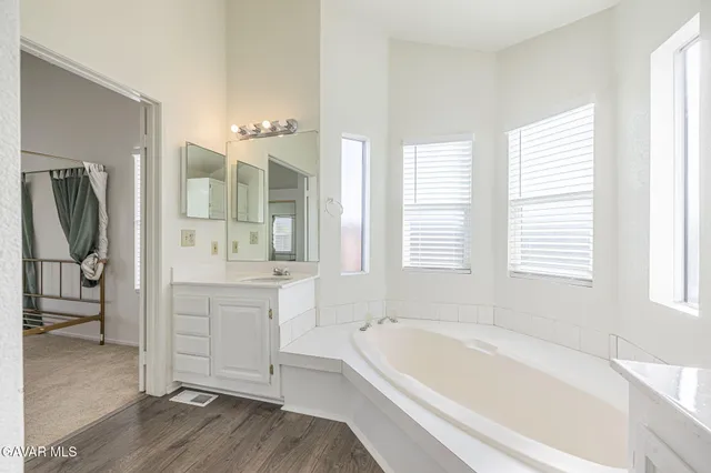 a bathroom with a tub sink and mirror