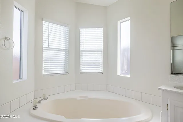 a white bath tub sitting in a bathroom next to a window