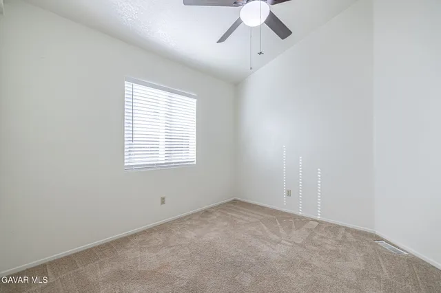 an empty room with a window and a fan