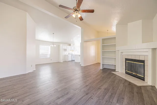 a view of empty room with wooden floor and fireplace