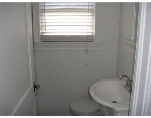 a bathroom with a window sink vanity and toilet