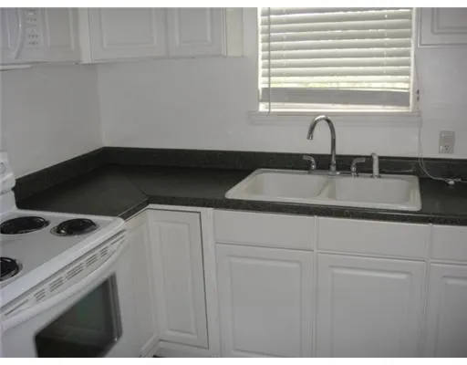 a kitchen with a sink cabinets and window