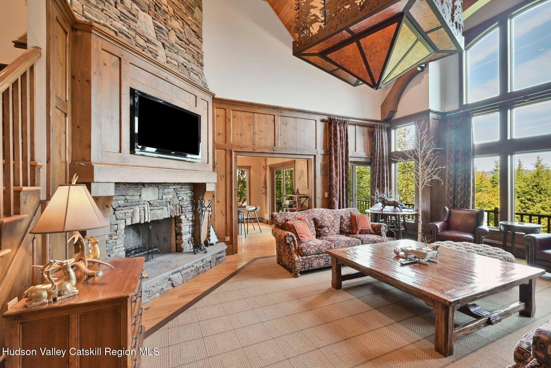 19 Twin Maples Lane Windham, NY 12496 - Photo 13 of 109 a living room with furniture a flat screen tv and a fireplace