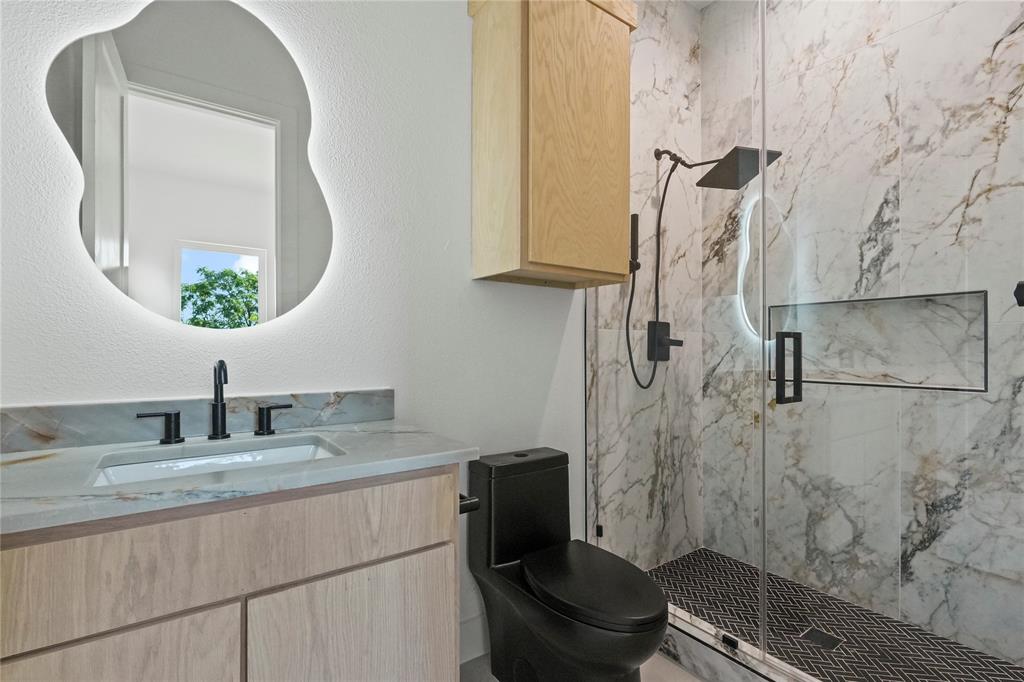 1823 Pollard Street Dallas, TX 75208 - Photo 14 of 28 Bathroom featuring a marble finish shower, vanity, and a textured wall
