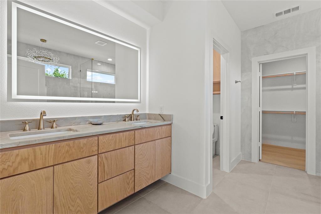 1823 Pollard Street Dallas, TX 75208 - Photo 17 of 28 Bathroom with double vanity, a walk in closet, tile patterned flooring, and a shower