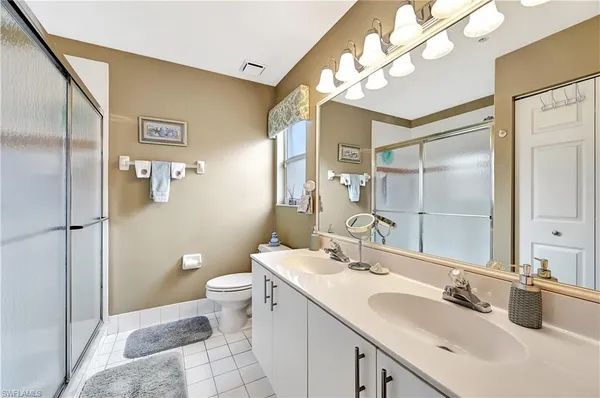 a bathroom with a sink a toilet a large mirror and shower
