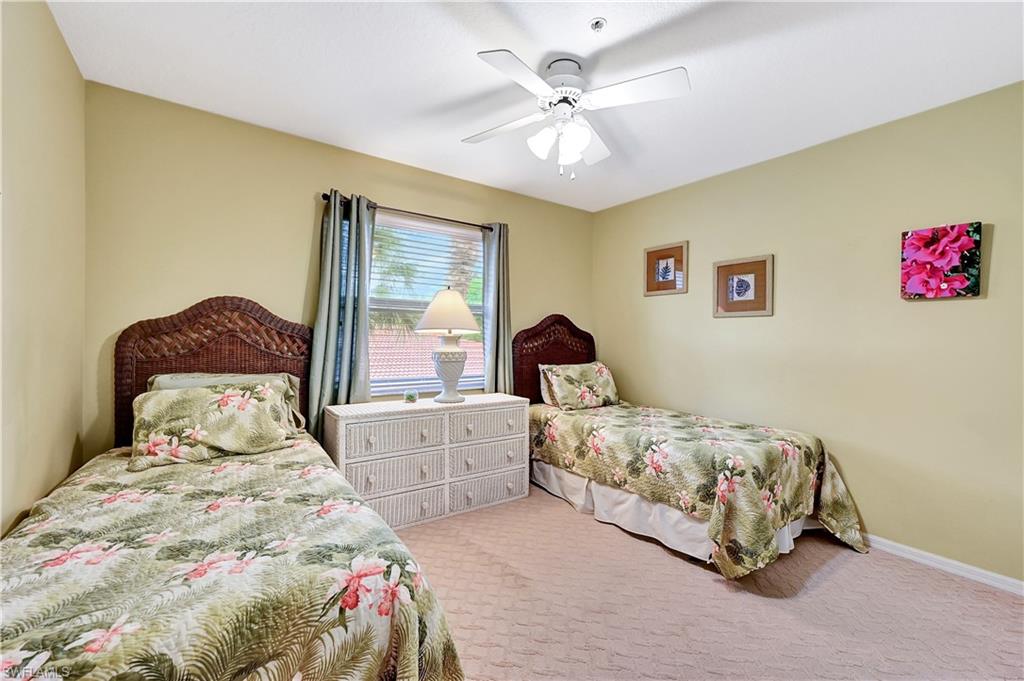 6496 Huntington Lakes Circle, Unit 201 Naples, FL 34119 - Photo 20 of 24 a bedroom with a bed and a chandelier
