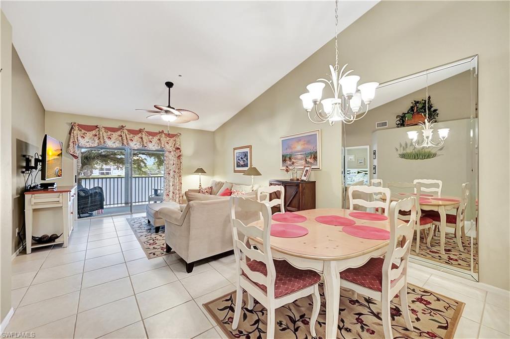 6496 Huntington Lakes Circle, Unit 201 Naples, FL 34119 - Photo 2 of 24 a living room with patio dining table and chairs