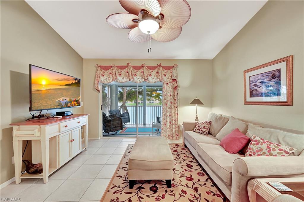 6496 Huntington Lakes Circle, Unit 201 Naples, FL 34119 - Photo 5 of 24 a living room with furniture and a flat screen tv