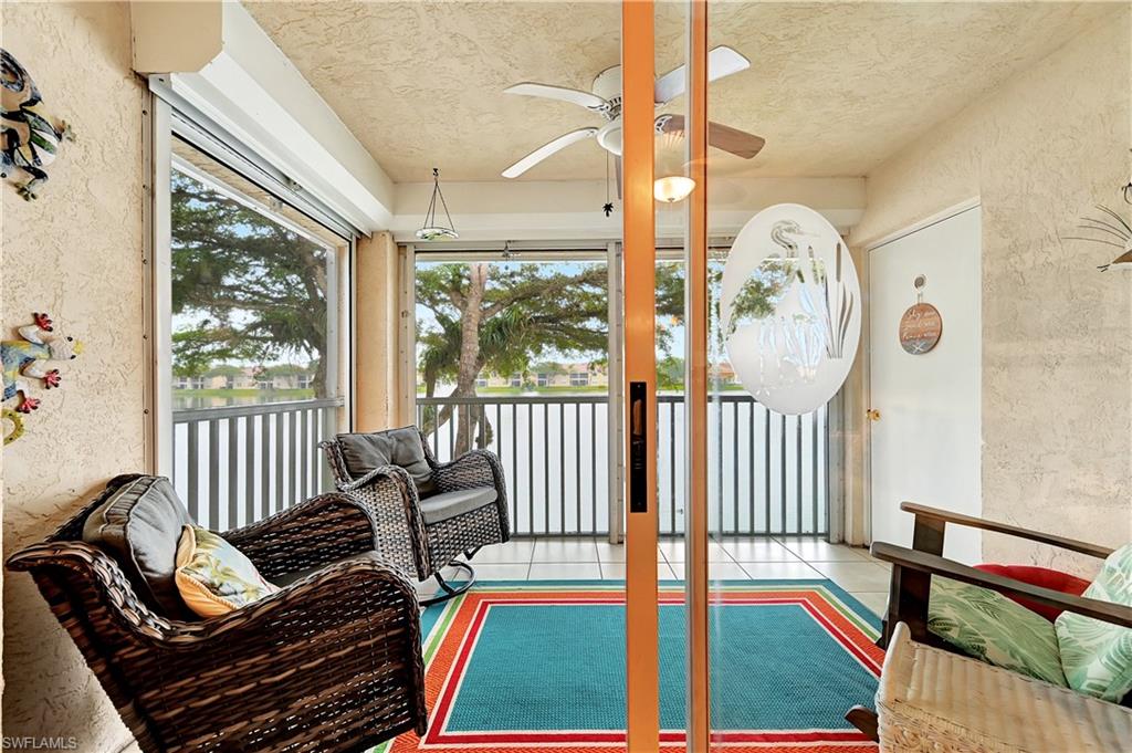 6496 Huntington Lakes Circle, Unit 201 Naples, FL 34119 - Photo 6 of 24 a living room with furniture and a floor to ceiling window