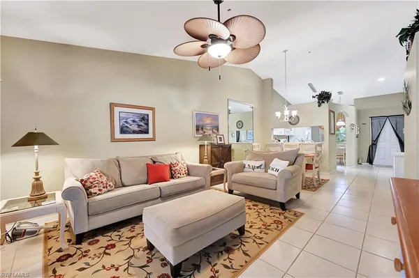 a living room with furniture potted plant and a chandelier