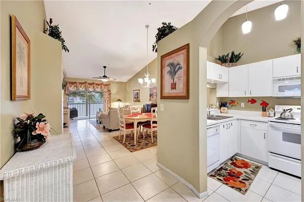 a living room with stainless steel appliances furniture and a kitchen view