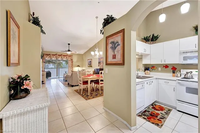 a living room with stainless steel appliances furniture and a kitchen view