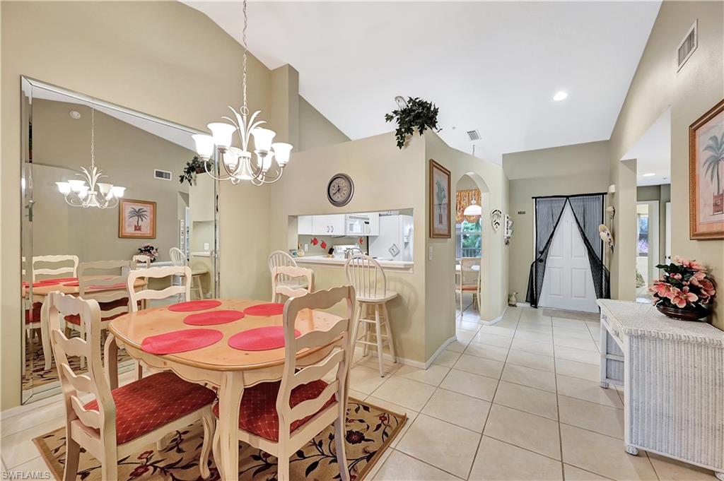 6496 Huntington Lakes Circle, Unit 201 Naples, FL 34119 - Photo 10 of 24 a view of a dining room with furniture and chandelier