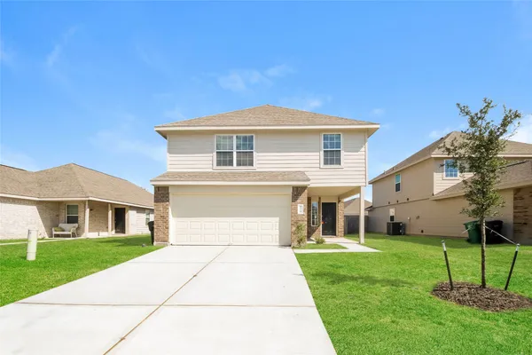 a front view of a house with a yard and trees
