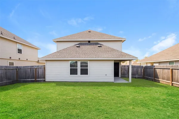 a view of a house with a yard and wooden fence