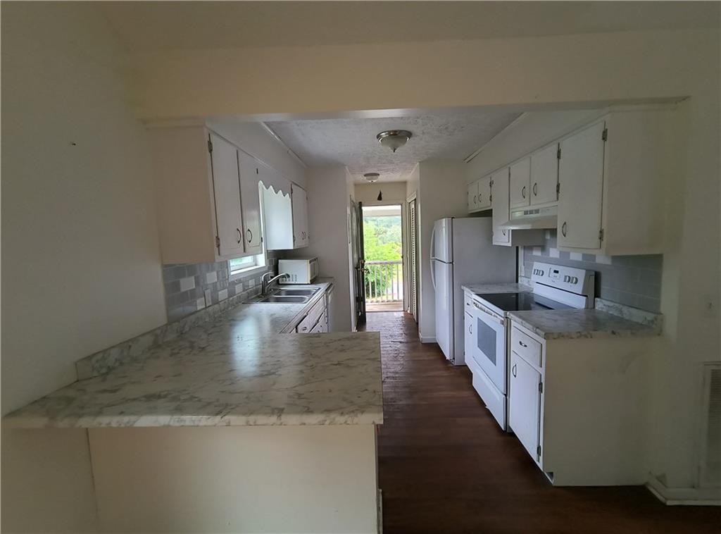 89 Murray Springs Road Chatsworth, GA 30705 - Photo 6 of 14 a large kitchen with stainless steel appliances granite countertop a sink a stove top oven a counter space and cabinets