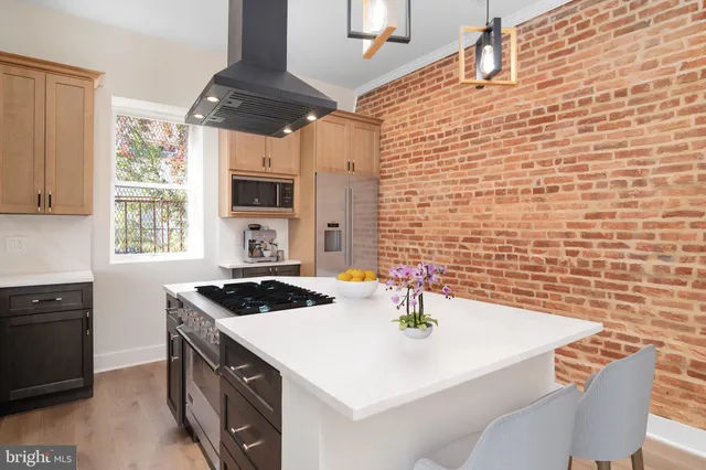 a kitchen with a sink a stove and wooden floor