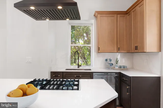 a kitchen with a sink a stove and white cabinets