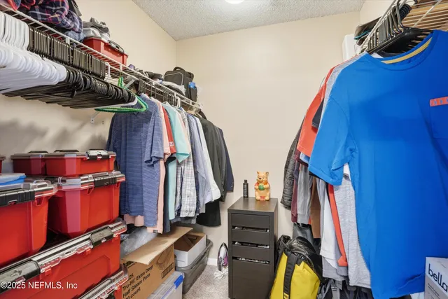 a view of walk in closet with clothes and shoes