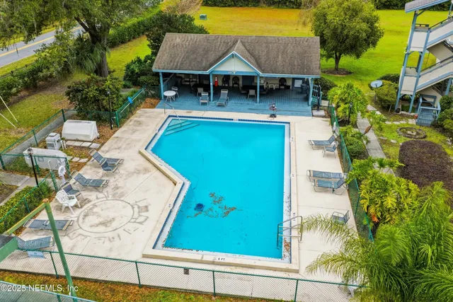 an aerial view of a house with swimming pool lawn chairs and a yard