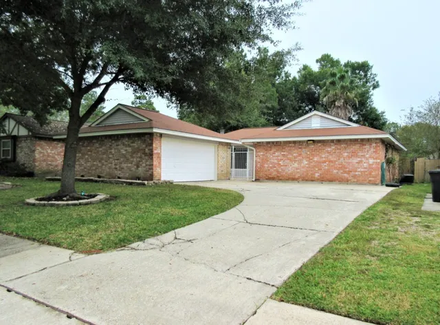 a front view of a house with a garden and trees