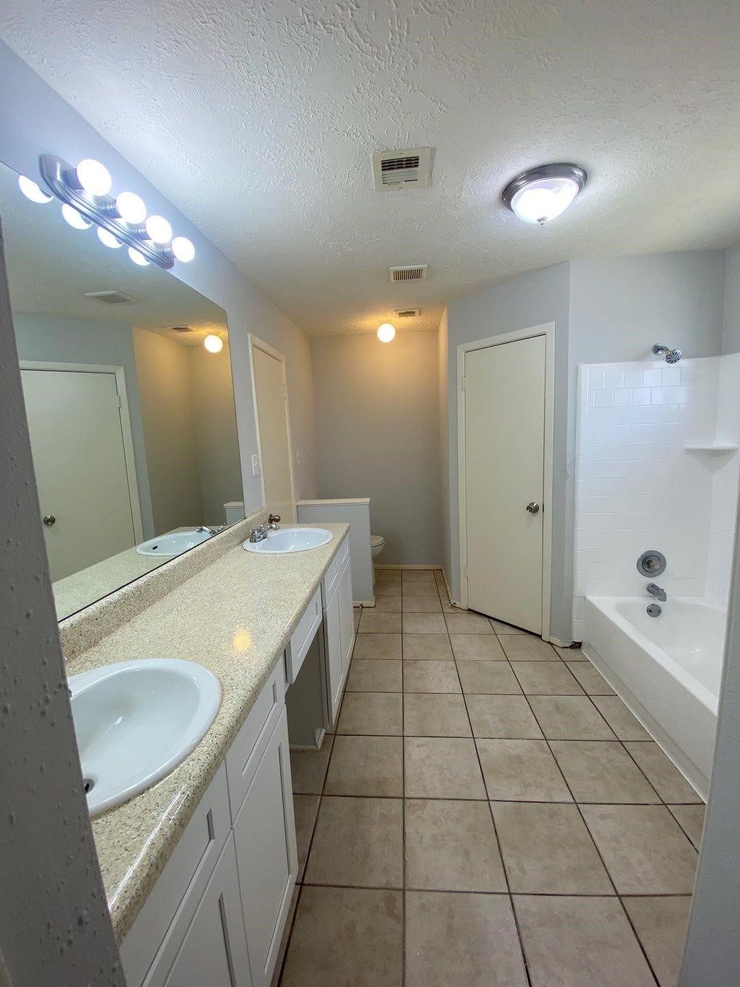 6406 Brookgate Drive Spring, TX 77373 - Photo 21 of 28 a spacious bathroom with a granite countertop sink a toilet a mirror and shower