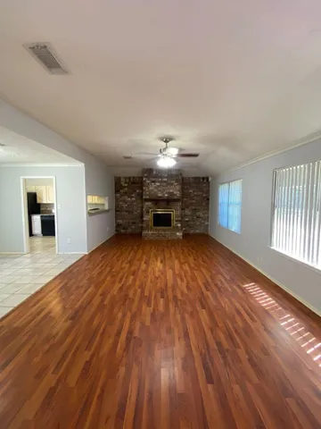 a view of empty room with wooden floor