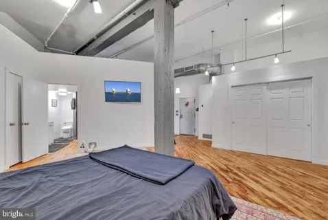 a bedroom with a large bed and a chandelier