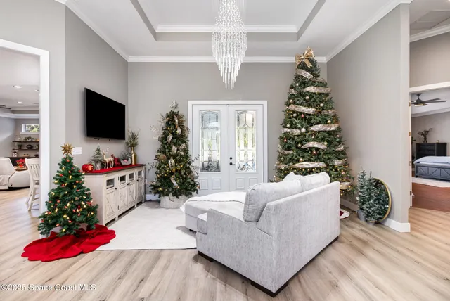 a view of a dining room with furniture a chandelier and wooden floor