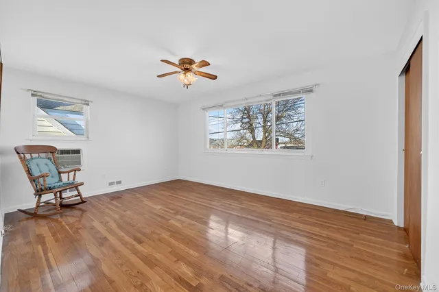 a view of room with hardwood floor and a ceiling fan