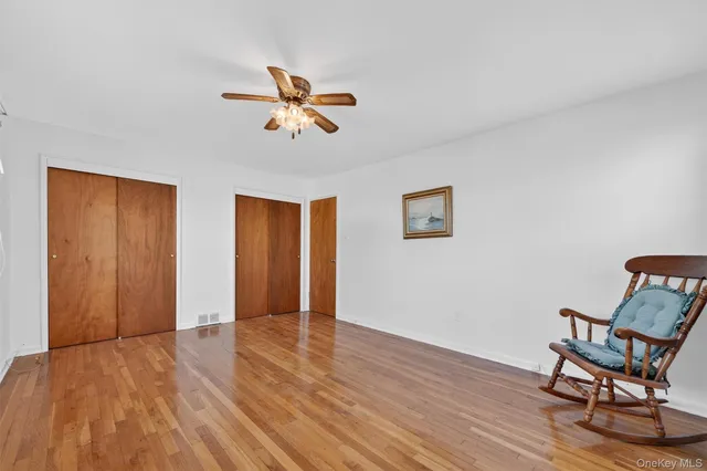 a view of a livingroom with wooden floor and a ceiling fan