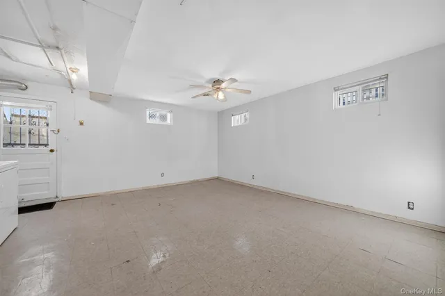 en empty room with windows and ceiling fan