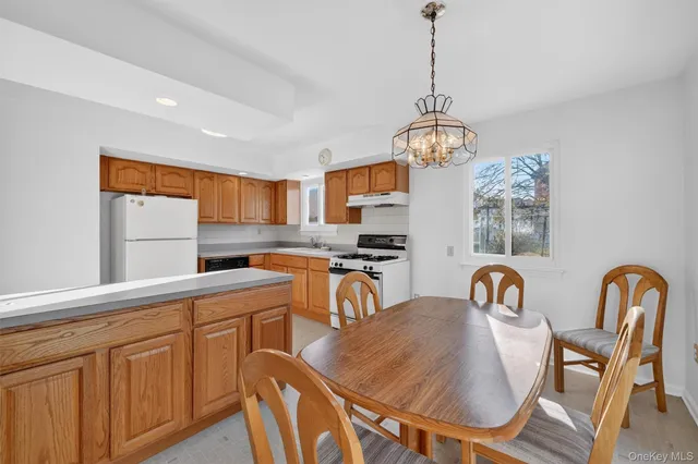 a dining room with stainless steel appliances granite countertop a dining table and chairs