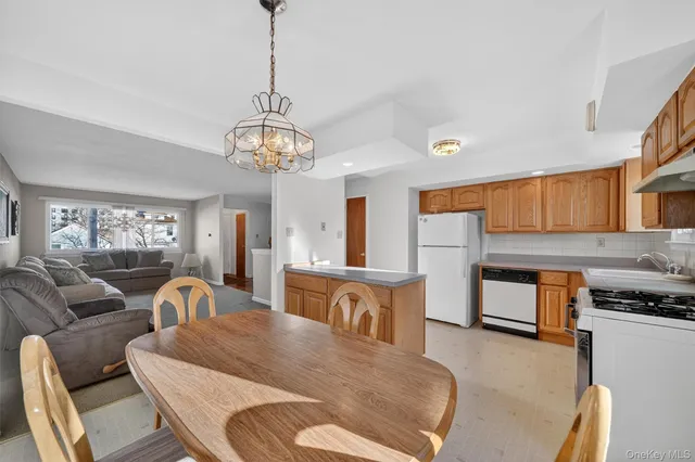 a living room with furniture a flat screen tv and kitchen view