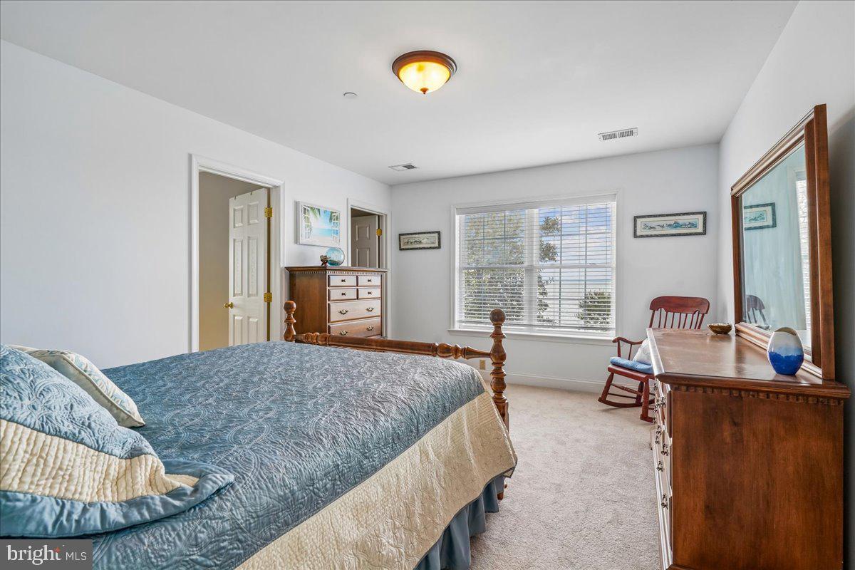 12195 Potomac View Road Newburg, MD 20664 - Photo 47 of 91 a spacious bedroom with a bed and a dresser next to a window