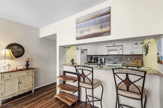 a kitchen with a stove cabinets and chairs