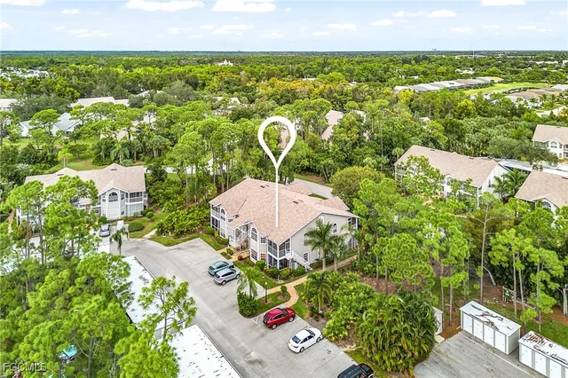 an aerial view of residential houses with outdoor space and trees