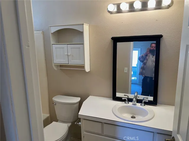 a bathroom with a sink and mirror with toilet