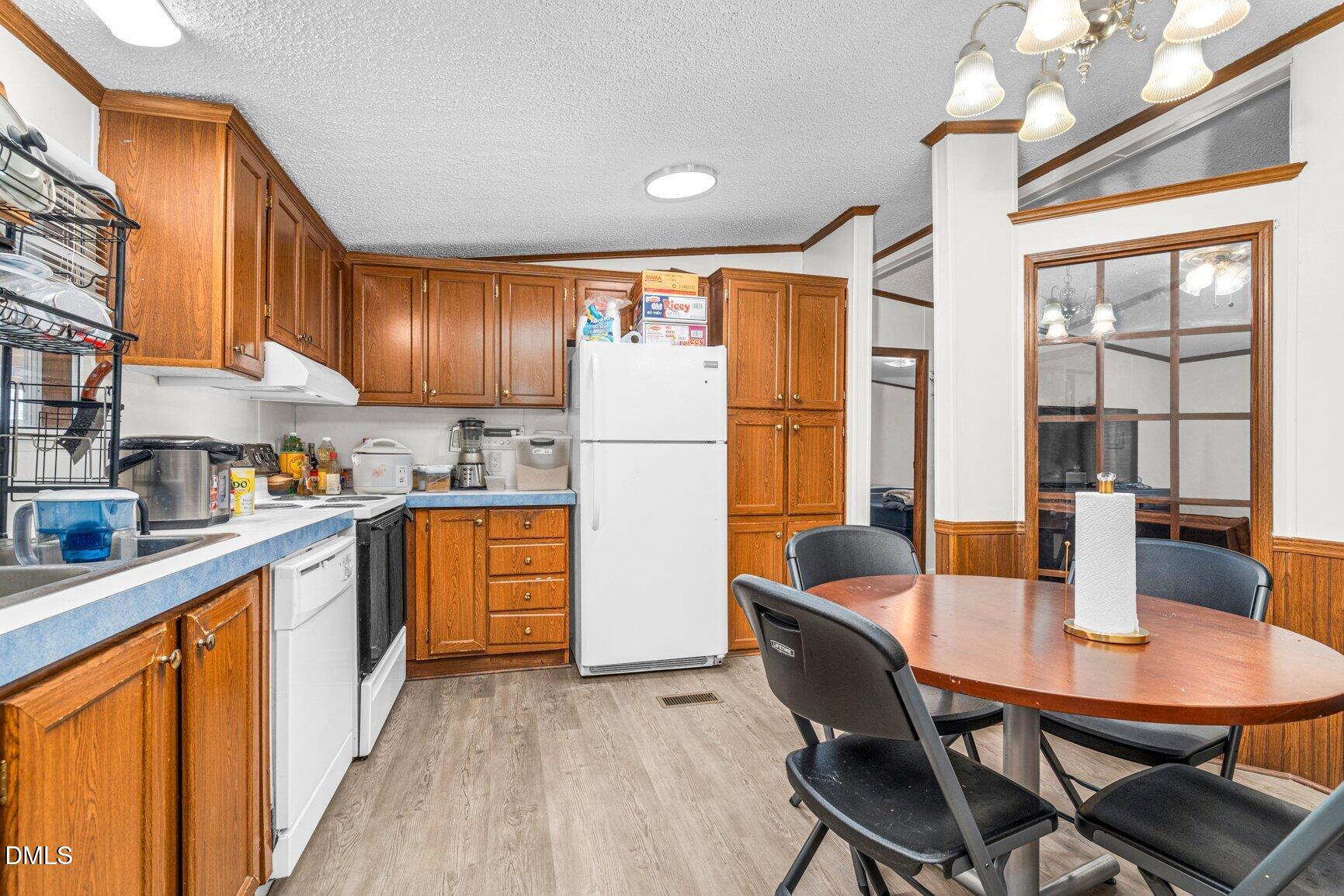 1835 Cokey Road Rocky Mount, NC 27801 - Photo 11 of 42 a kitchen with stainless steel appliances granite countertop a refrigerator a sink dishwasher a dining table and chairs with wooden floor