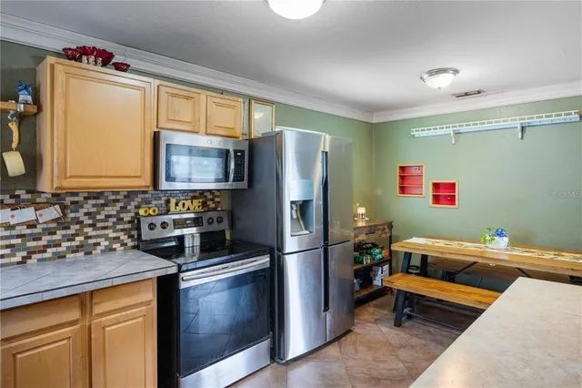 a kitchen with stainless steel appliances granite countertop a refrigerator and a sink