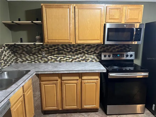 a kitchen with stainless steel appliances granite countertop a sink stove and microwave